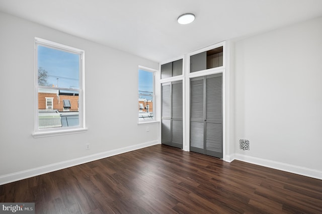 unfurnished bedroom with dark wood finished floors and baseboards