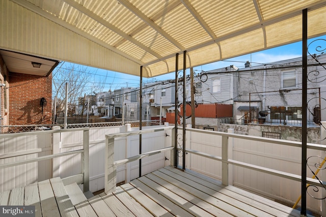 wooden terrace featuring a residential view and fence