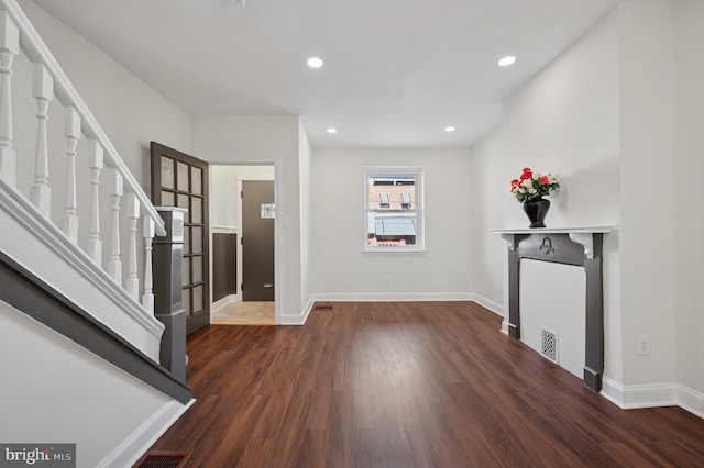 entryway with stairway, baseboards, and wood finished floors