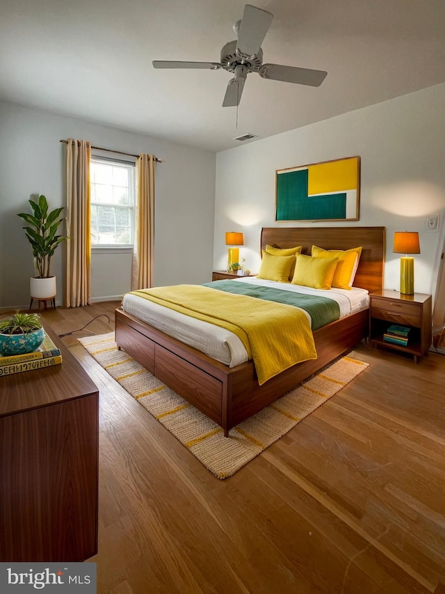 bedroom featuring visible vents, wood finished floors, and a ceiling fan