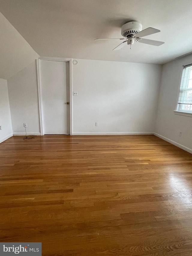 spare room featuring ceiling fan, baseboards, and wood finished floors