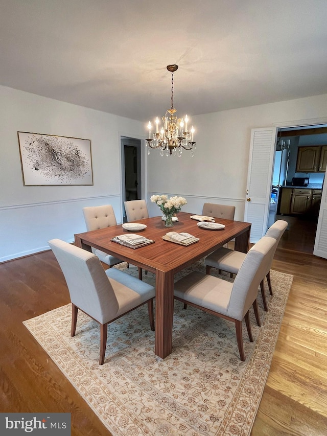 dining area with a chandelier and light wood finished floors