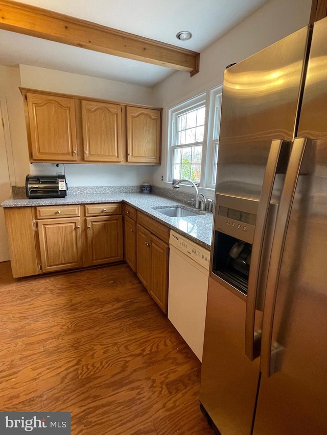 kitchen featuring dark wood-type flooring, stainless steel fridge with ice dispenser, beamed ceiling, dishwasher, and a sink