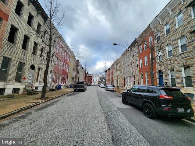 view of road featuring curbs, sidewalks, and street lighting