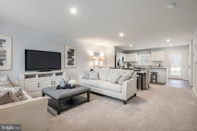 living area with recessed lighting and light colored carpet