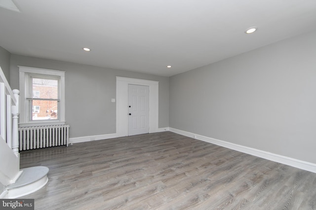 interior space featuring recessed lighting, radiator heating unit, wood finished floors, and baseboards