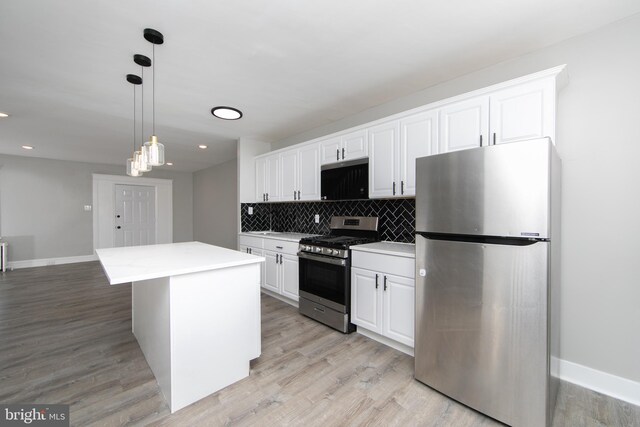 kitchen with white cabinetry, light wood-style flooring, backsplash, and appliances with stainless steel finishes