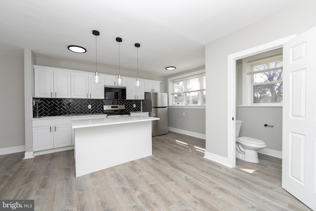 kitchen featuring light countertops, white cabinets, tasteful backsplash, and stainless steel appliances