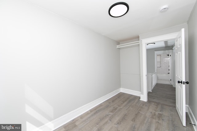 unfurnished bedroom featuring wood finished floors and baseboards