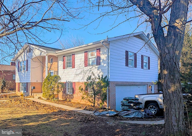 raised ranch featuring brick siding and a garage