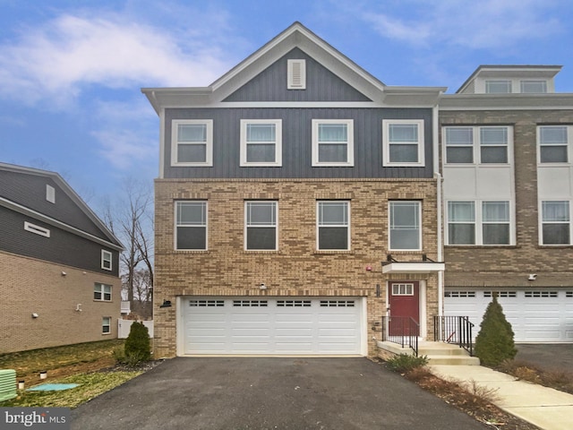 multi unit property featuring brick siding, an attached garage, and aphalt driveway