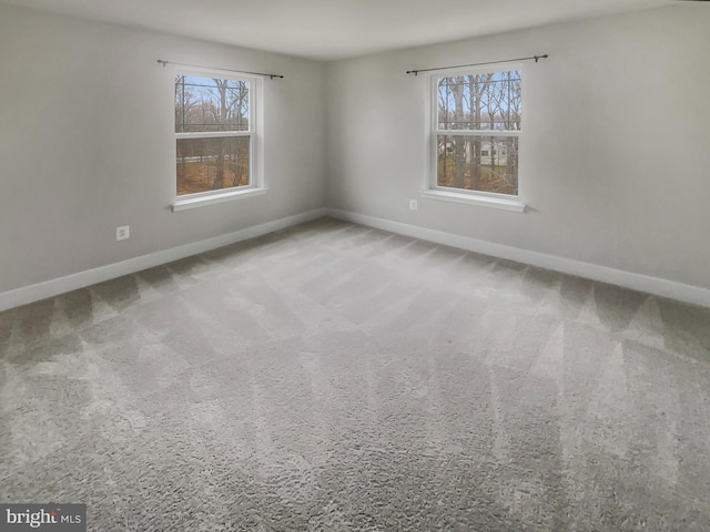 unfurnished room with carpet and baseboards