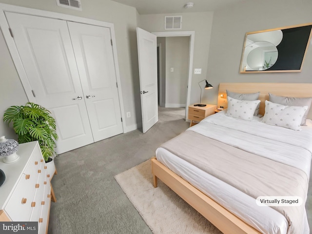 carpeted bedroom with a closet, visible vents, and baseboards