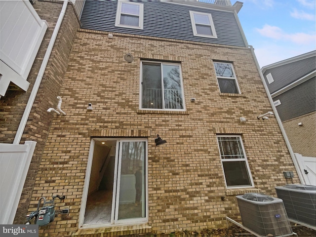 rear view of house with brick siding and central AC