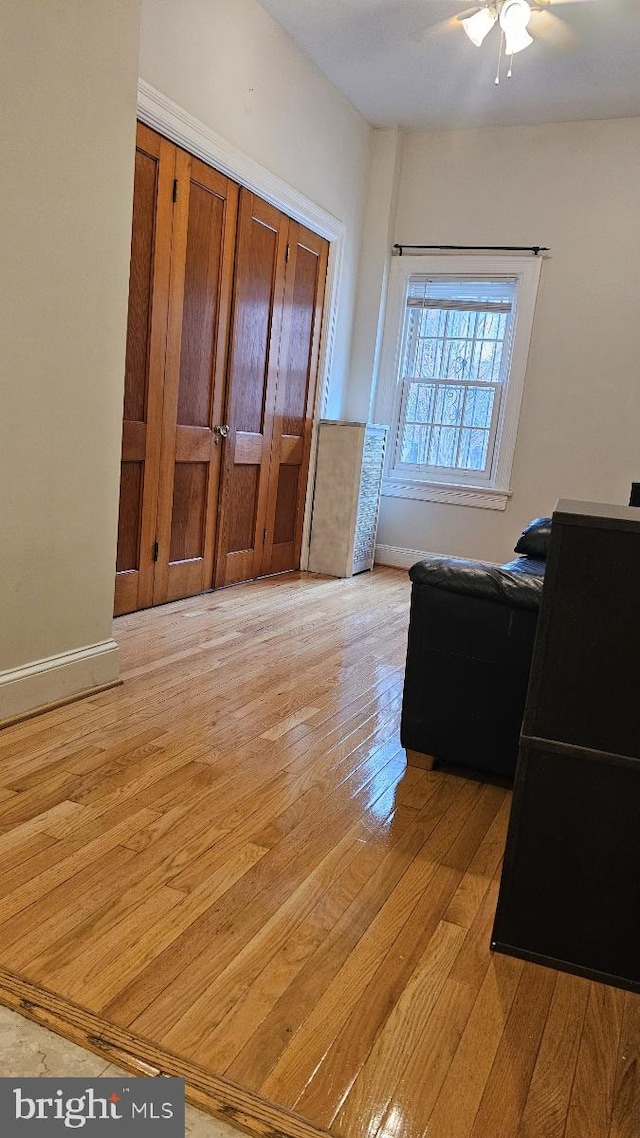 home office featuring baseboards, light wood-style floors, and a ceiling fan