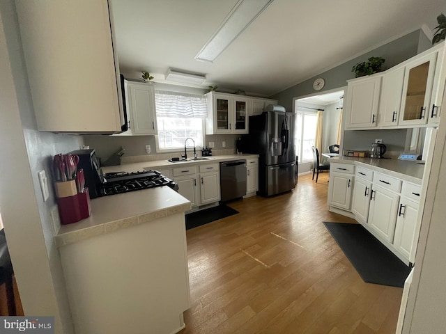 kitchen with a sink, plenty of natural light, black appliances, and light wood-style flooring