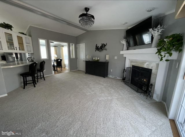 carpeted living room featuring vaulted ceiling, baseboards, and a premium fireplace