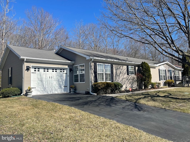 ranch-style house featuring an attached garage, a shingled roof, driveway, and a front lawn