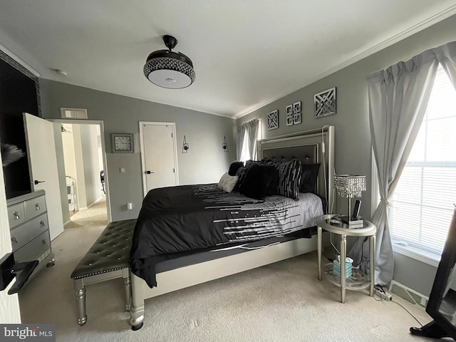 carpeted bedroom with multiple windows and lofted ceiling