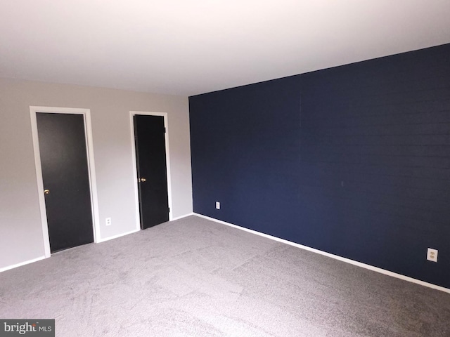 empty room featuring carpet flooring and baseboards