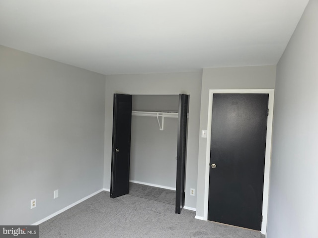 unfurnished bedroom with carpet, baseboards, and a closet