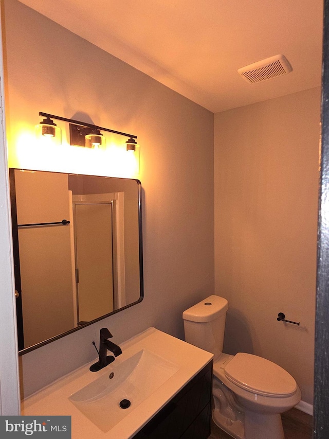 bathroom with visible vents, toilet, and vanity