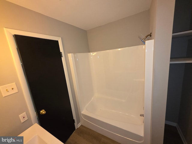 bathroom with bathtub / shower combination and wood finished floors