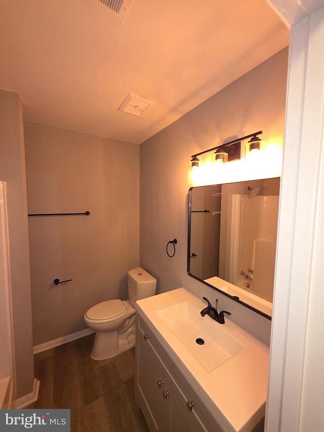 full bath featuring baseboards, toilet, wood finished floors, vanity, and a shower