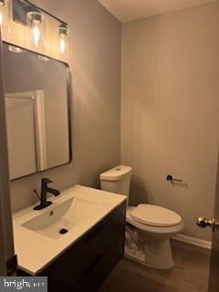 bathroom with vanity, toilet, and baseboards