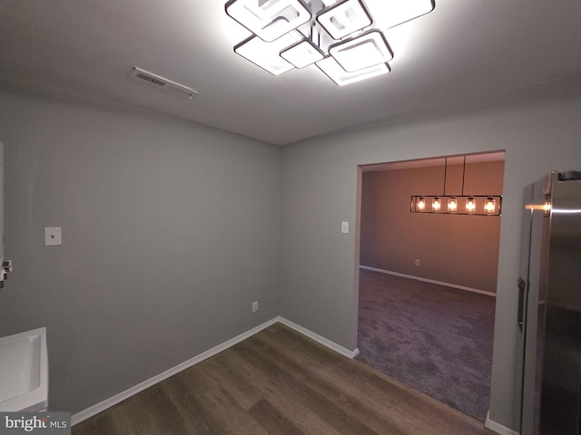 spare room with dark wood-type flooring, baseboards, and visible vents