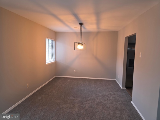 empty room featuring baseboards and dark carpet