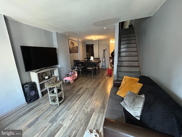 living area featuring stairway and wood finished floors