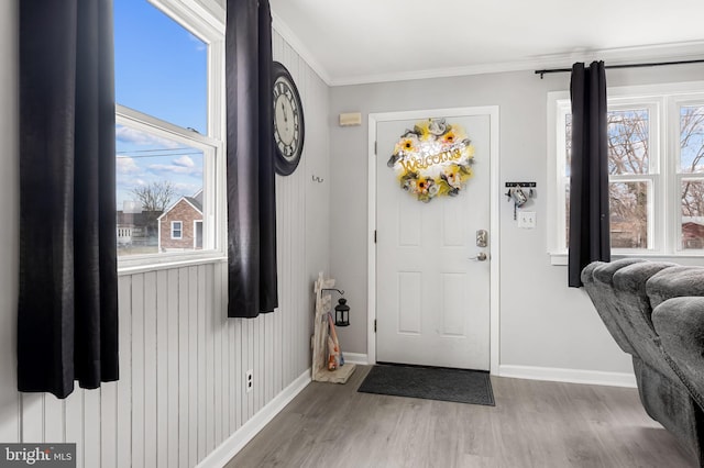 entrance foyer featuring baseboards, wood finished floors, and crown molding