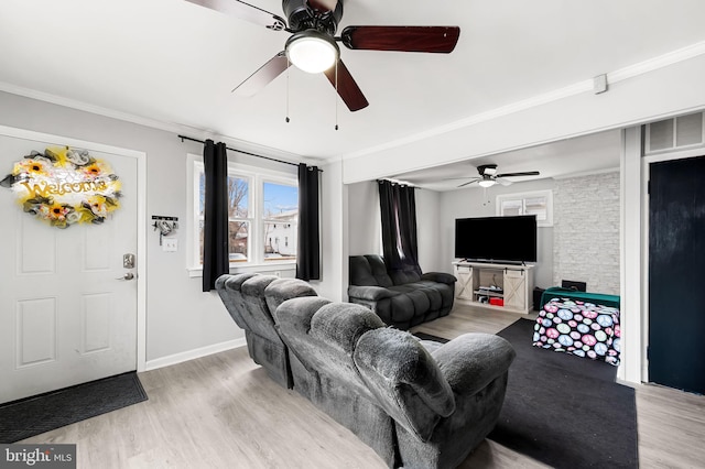 living area with light wood-style floors, ceiling fan, and ornamental molding