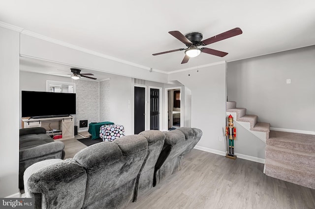 living room with stairway, ornamental molding, a ceiling fan, and wood finished floors