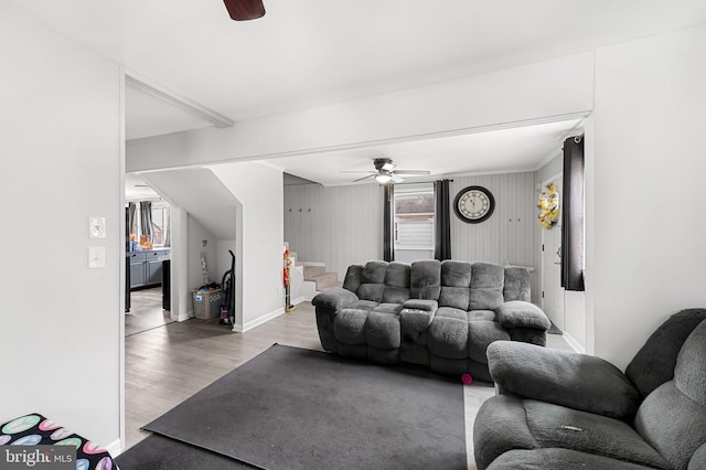 living area with baseboards, wood finished floors, and a ceiling fan