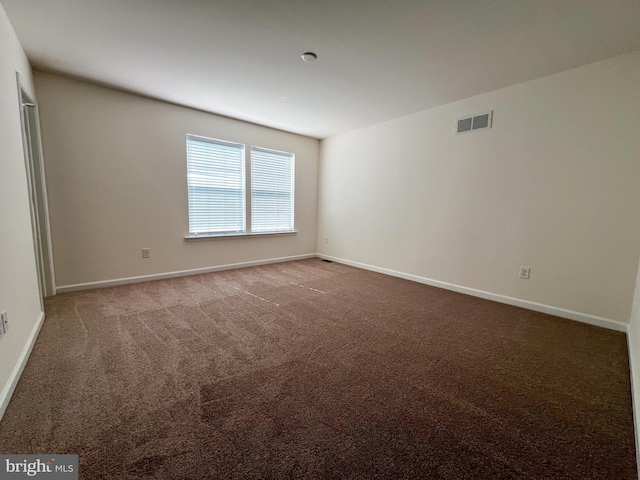 spare room with visible vents, baseboards, and carpet