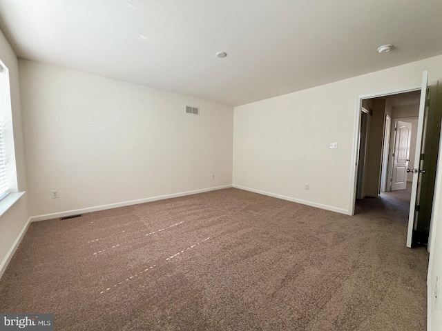 unfurnished room with visible vents, baseboards, and carpet