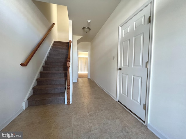 stairs featuring tile patterned flooring and baseboards