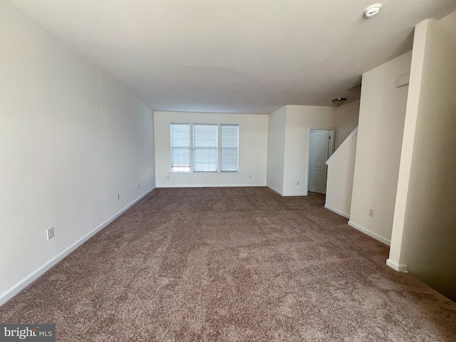 unfurnished living room featuring baseboards and carpet flooring