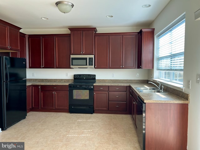 kitchen with a sink, reddish brown cabinets, black appliances, and recessed lighting