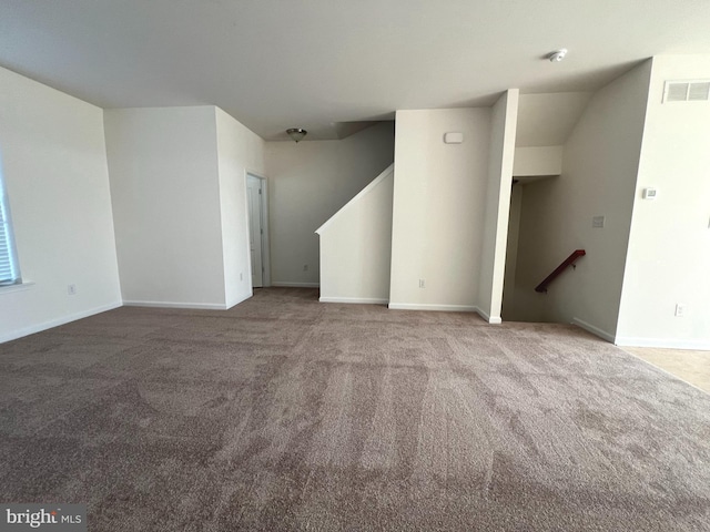 unfurnished living room featuring visible vents, baseboards, and carpet