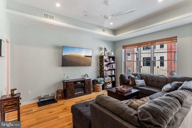 living room with light wood-type flooring, visible vents, a ceiling fan, and recessed lighting