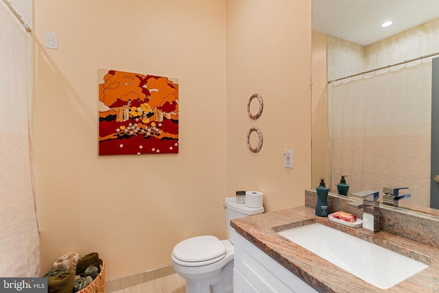 bathroom with vanity, curtained shower, and toilet