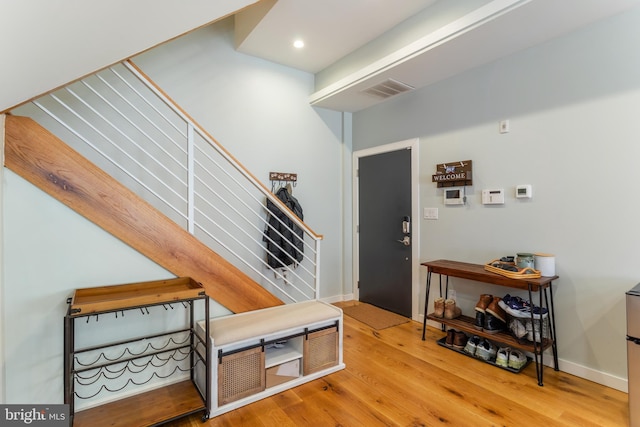 interior space featuring stairway, wood finished floors, visible vents, baseboards, and recessed lighting