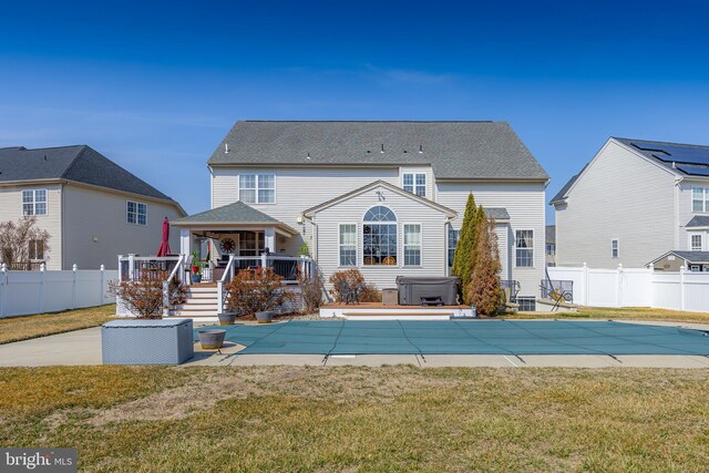 rear view of house featuring a wooden deck, a patio area, a fenced backyard, and a hot tub