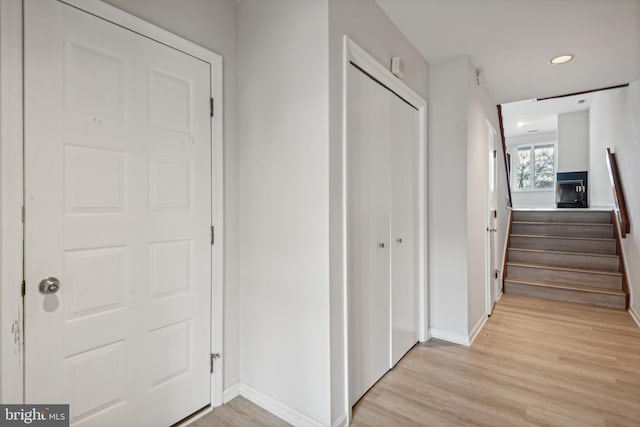 corridor with recessed lighting, baseboards, stairs, and light wood-style floors