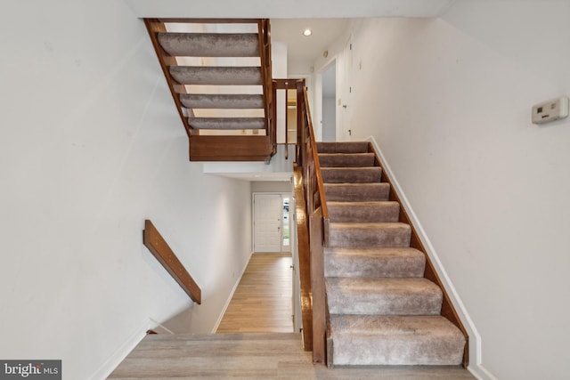 stairs featuring recessed lighting and wood finished floors