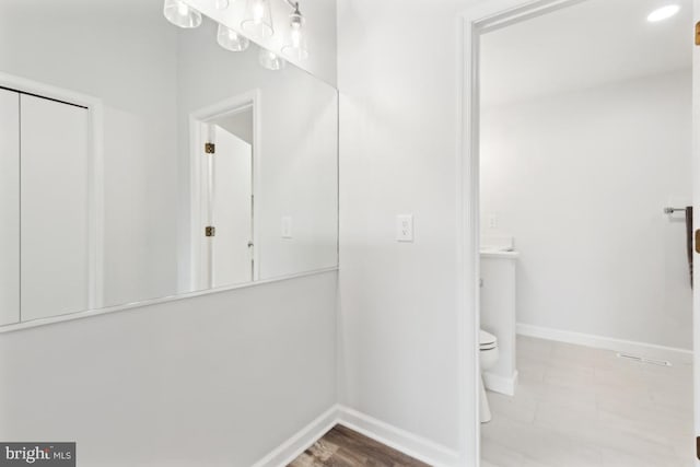 bathroom with baseboards and toilet