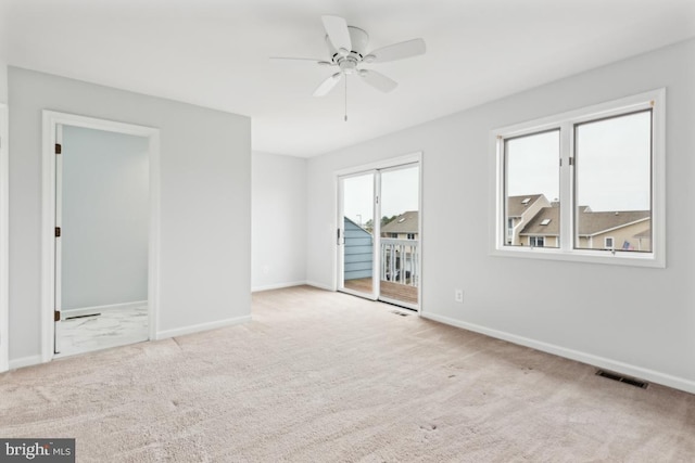 empty room featuring baseboards, carpet floors, and ceiling fan